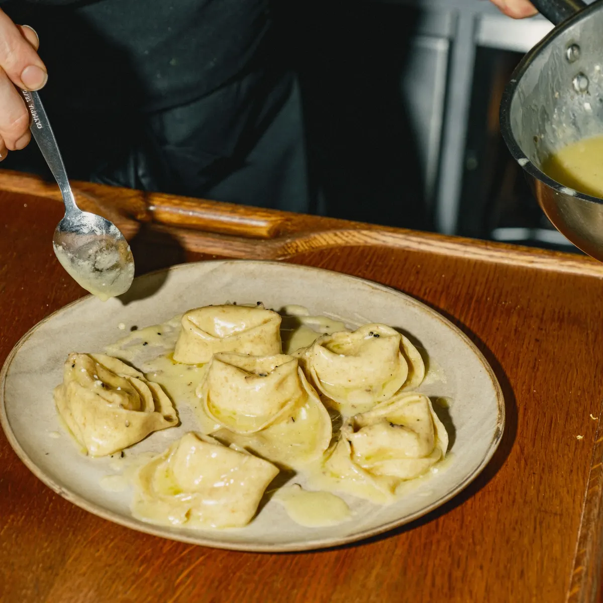 Frisch zubereitete gefüllte Pasta wird mit Sauce angerichtet